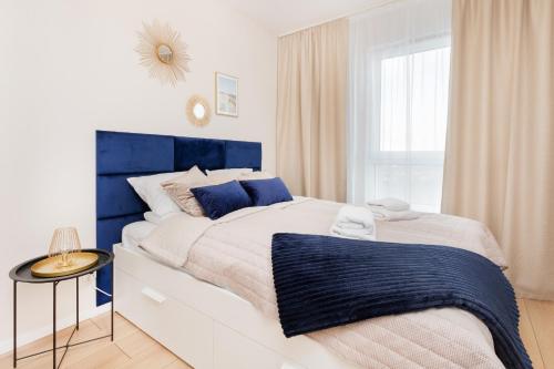 格但斯克Apartment Sucha Nowa Letnica by Renters的白色和蓝色的卧室设有一张大床