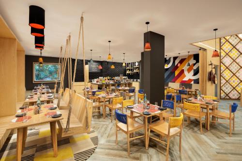 苏拉特金吉尔苏拉特酒店的用餐室配有木桌和椅子