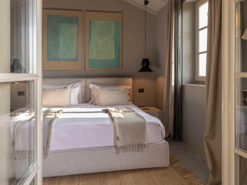 布耶San Canzian Hotel & Residences - Small Luxury Hotels of the World的一间卧室配有带白色床单和枕头的床。