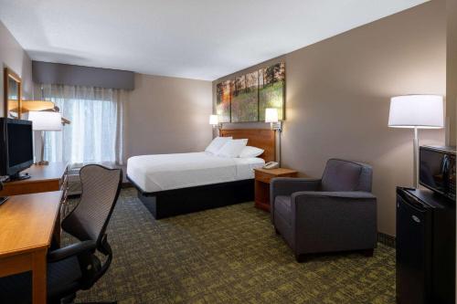 麦迪逊南麦迪逊/莫诺纳戴斯套房酒店的酒店客房,配有一张床、一张桌子和椅子