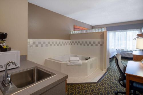 麦迪逊南麦迪逊/莫诺纳戴斯套房酒店的带浴缸和盥洗盆的酒店浴室