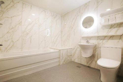 天安市Urban Stay的白色的浴室设有卫生间和水槽。