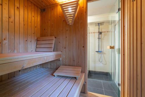 拉罗什-阿登Au Ptit Bois Charmant的一个带长凳和淋浴的桑拿浴室
