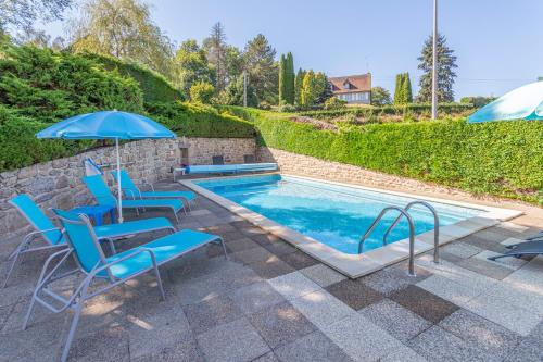 BourganeufLe Petit Lac的一个带蓝色椅子和遮阳伞的游泳池