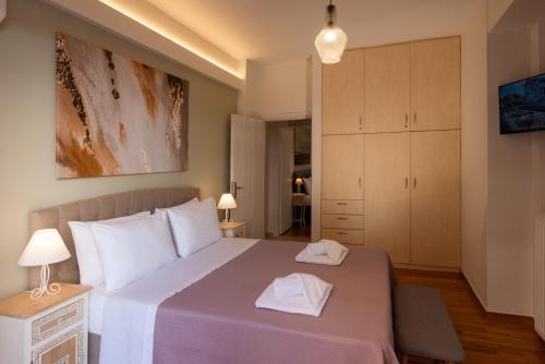 雅典Blue Ark Acropolis Compass的一间卧室配有一张大床和两条毛巾