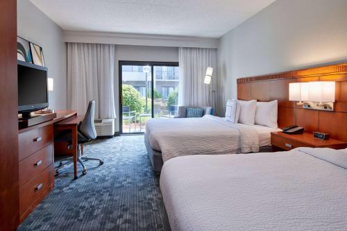 伊甸草原明尼阿波利斯庭院伊甸草原酒店的酒店客房设有两张床、一张桌子和一台电视。
