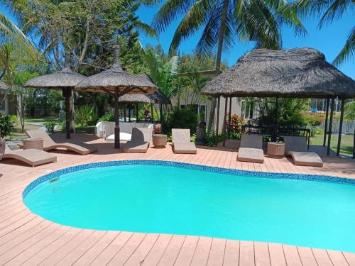 蒙舒瓦西毛里求斯舒瓦西旅馆的一个带椅子和遮阳伞的游泳池