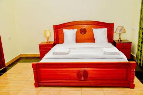 基加利Freedom Homes Kigali的卧室里一张大木床,设有2个床头柜