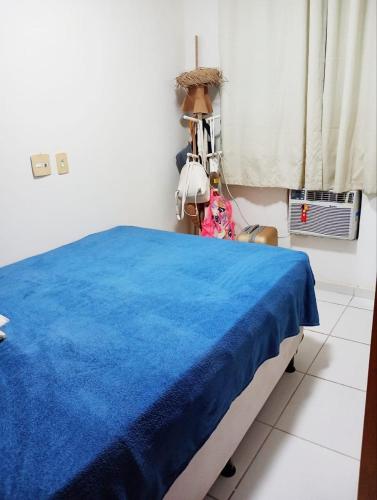 累西腓Apê da Mel - Recife PE的一间设有一张蓝色毯子的床的客房