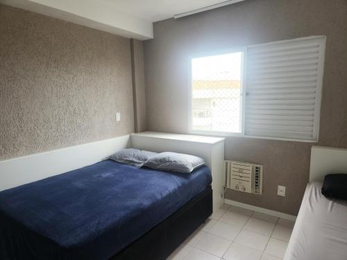 弗洛里亚诺波利斯Apartamento pe na areia e com vista linda的一间卧室配有一张带蓝色床单的床和一扇窗户。