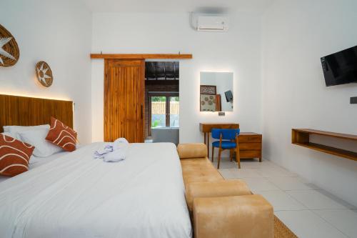 新加拉惹Bali Taoka Beach Villa的卧室配有一张白色的大床和一张沙发。