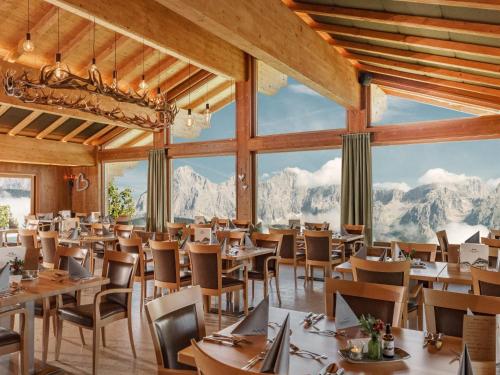 皮彻尔Holiday Home Hirtabua by Interhome的餐厅配有桌椅,位于山脉的背景中。