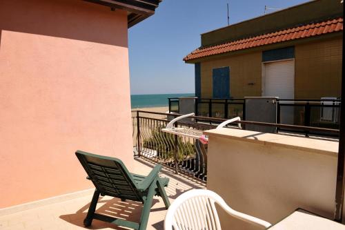 玛格丽塔萨沃亚La Perla delle Saline的海滩阳台的绿椅和两把椅子