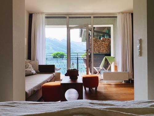 巴德加斯坦豪斯希尔特高山Spa酒店的带沙发的客厅和阳台美景