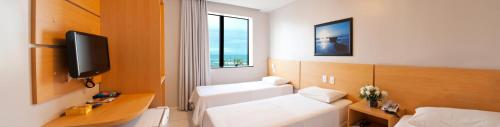 萨尔瓦多阿布索路特酒店的配有一张床和一台平面电视的酒店客房