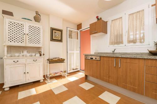 GuadiaroSpikes的厨房配有木制橱柜和瓷砖地板。