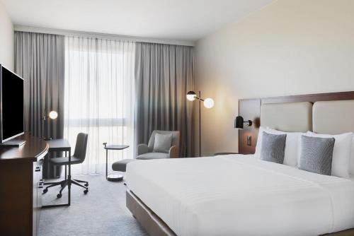 普拉特恩巴塞尔万怡酒店的酒店客房设有一张大床和一张书桌。
