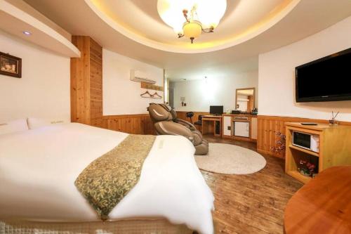 天安市Cheonan Business Hotel的一间卧室配有一张大床和一台平面电视