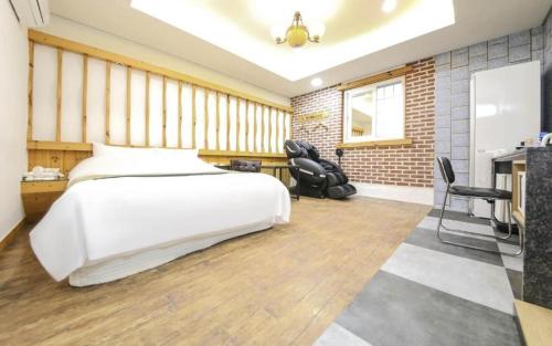 天安市Cheonan Business Hotel的卧室配有一张白色大床和两把椅子