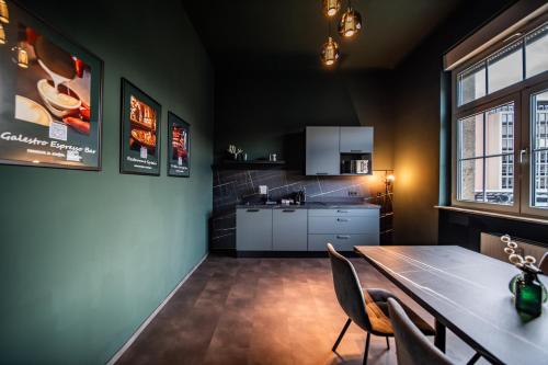 科布伦茨LLR Design Apartment - Emerald Green im Zentrum von Koblenz的厨房以及带桌椅的用餐室。