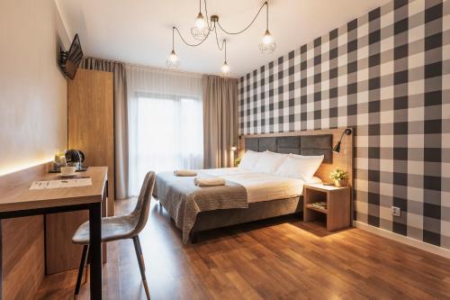 西恩纳Złote Góry的酒店客房配有一张床、一张书桌和一张书桌。