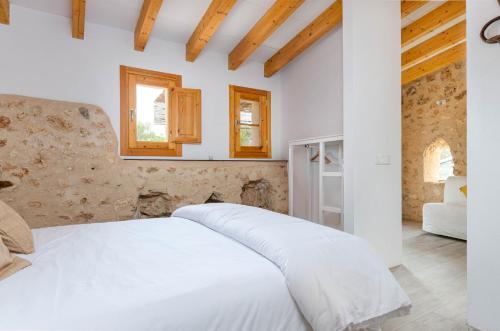 科斯提克斯Cal Tio 1 Agroturismo YourHouse的木制天花板的白色床
