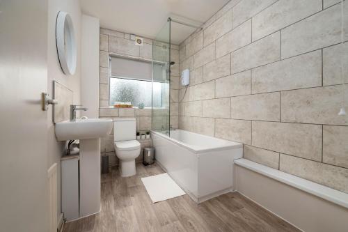 塔姆沃思Watling Apartments Tamworth的浴室配有盥洗盆、卫生间和浴缸。