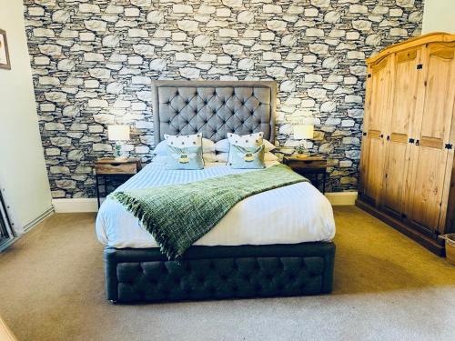 斯卡伯勒Old Orchard Cottage, Wykeham的一间卧室设有一张带石墙的大床