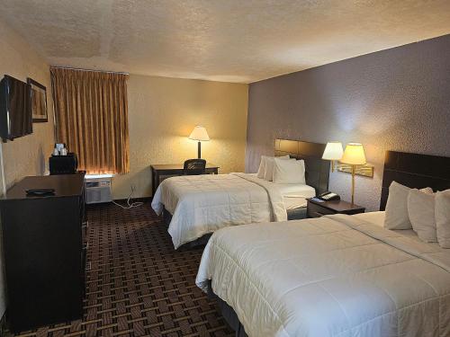 迈尔斯堡Rodeway Inn Fort Myers Central的酒店客房设有两张床和两盏灯。