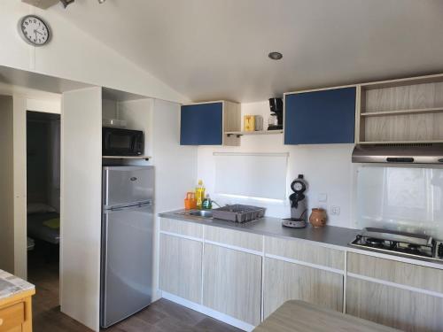 纳博讷Mobil-home cosy 166的厨房配有不锈钢用具和蓝色橱柜