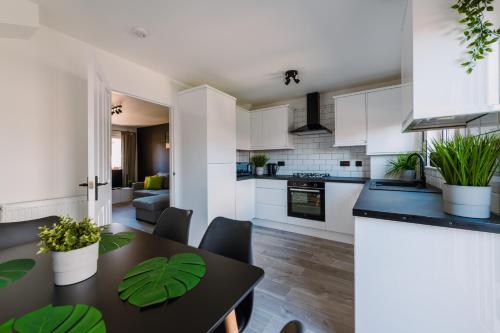 格拉斯哥Emirates ApartHOUSE的厨房以及带桌椅的起居室。