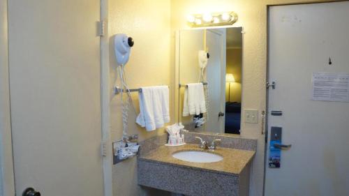 迈尔斯堡Rodeway Inn Fort Myers Central的一间带水槽和镜子的浴室