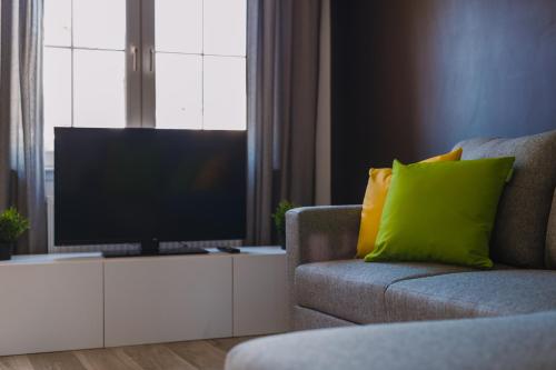 格拉斯哥Emirates ApartHOUSE的一间带电视和沙发的客厅