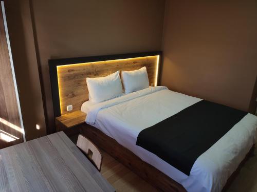 宗古尔达克ONKA OTEL的一间卧室配有一张大床和木制床头板