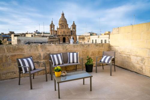 SiġġiewiThe Siggiewi Suites的美景阳台配有三把椅子和一张桌子