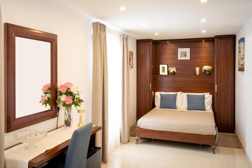 SiġġiewiThe Siggiewi Suites的一间卧室配有一张床和一张带花瓶的书桌