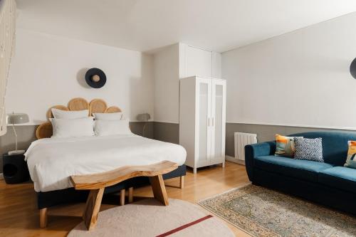 巴黎Edgar Suites Saint-Augustin - Naples的一间卧室配有一张床和一张蓝色的沙发