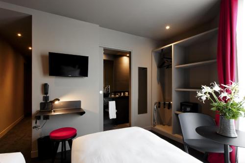 巴黎圣马塞尔酒店的酒店客房带一张床、一张桌子和椅子