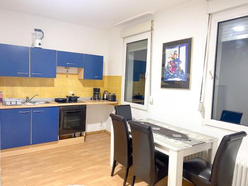 伍珀塔尔Shared Serenity accommodation的厨房配有蓝色橱柜和桌椅