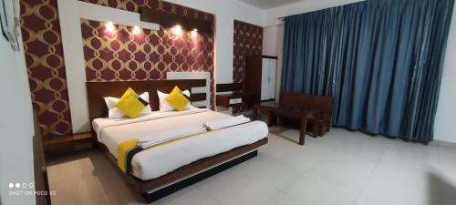 班加罗尔Suite Rooms Bellandhuru的一间卧室配有一张带黄色枕头的大床
