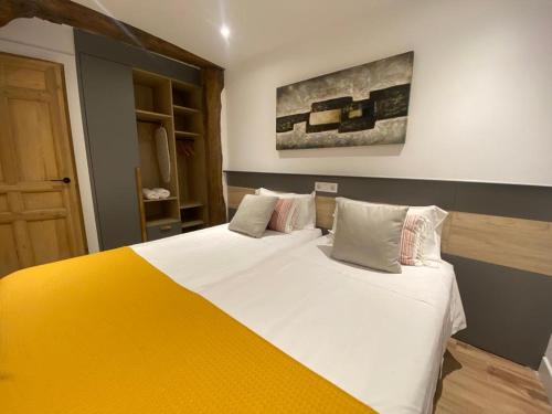 毕尔巴鄂Apartamento Deluxe Casco Viejo的一间卧室配有一张带黄色毯子的大床