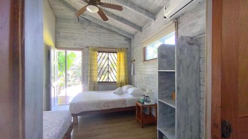 圣塔特蕾莎海滩Hotel Raratonga的一间卧室配有一张床和吊扇