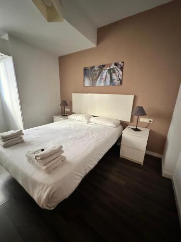 瓦伦西亚Zerka Centro的卧室配有带毛巾的大型白色床