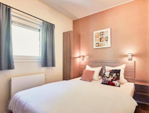 克拉姆萨赫菲林多夫西布里克托尼酒店的卧室配有带枕头的白色床和窗户。