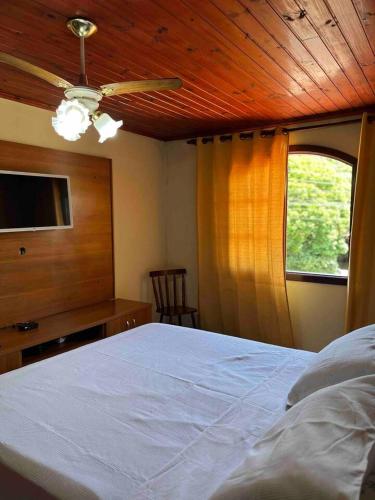 布希奥斯Casa Canto da Serra的一间卧室配有一张带吊扇和窗户的床。