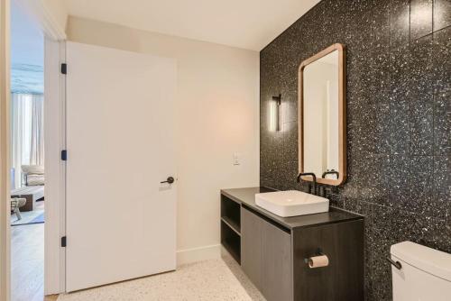 奥斯汀Luxury 1BR with Views, Rooftop Pool and Walk To Rainey St.的一间带水槽和镜子的浴室