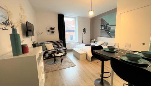 沙勒罗瓦Studio chic proche aéroport & centre-ville的客厅配有沙发和桌子。