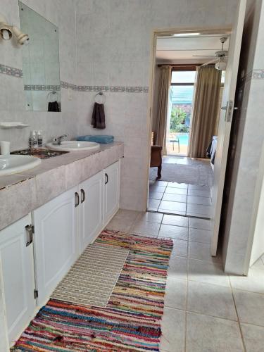 莫科帕内Emani Guest House的浴室设有水槽、镜子和地毯。