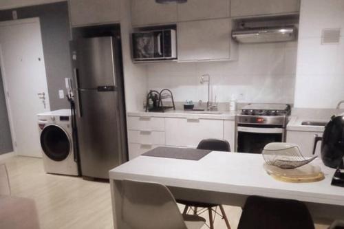 奥萨斯库Apto Aconchegante /excelente localização de Osasco的厨房配有冰箱和桌椅