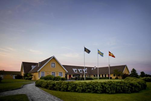 巴斯塔德Bjäre Golfklubb Hotel & Lodge的一群旗帜在房子前面飘扬